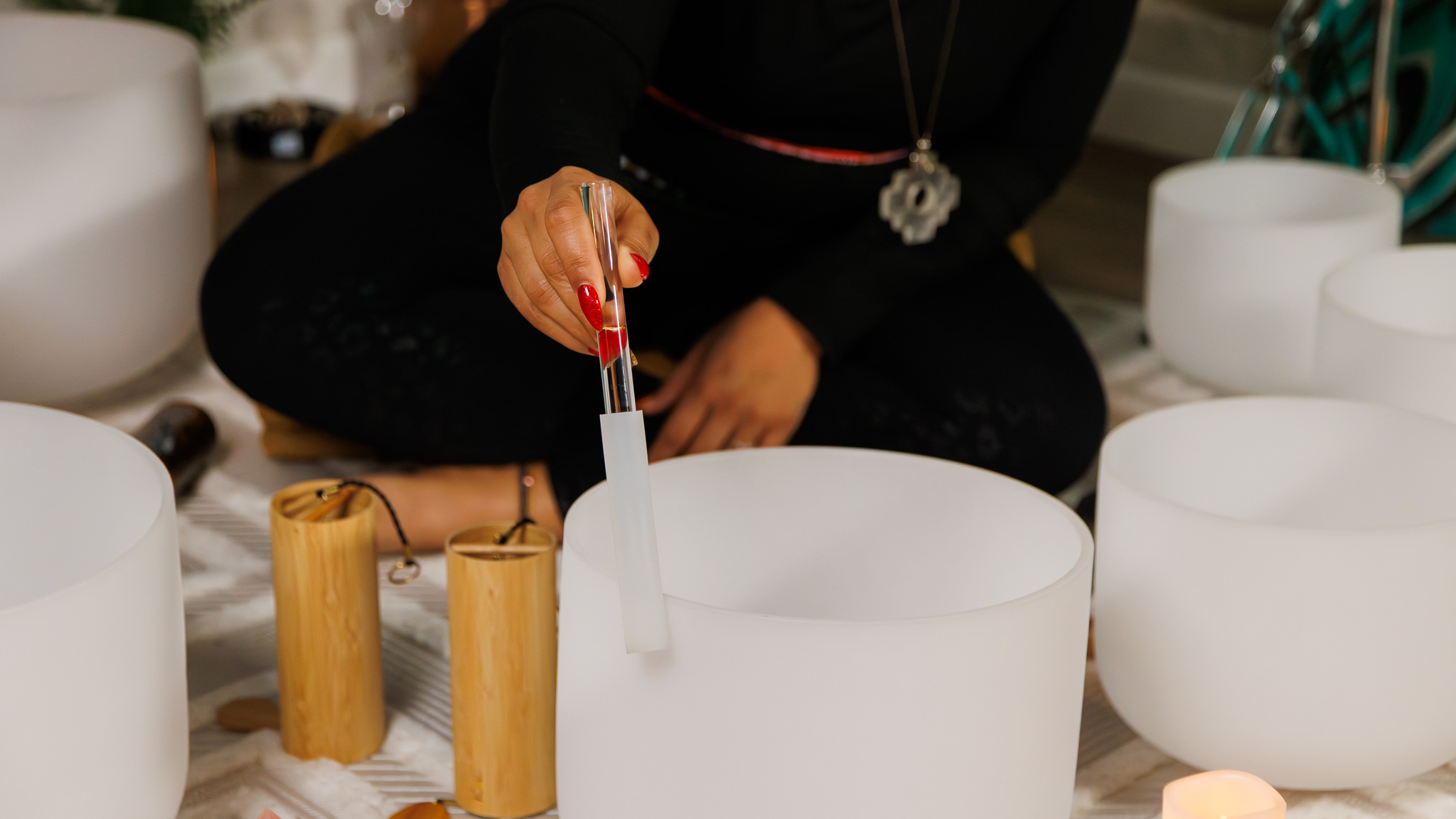 Close-up of Dr. Sharon GE Washington using a mallet to play a crystal singing bowl